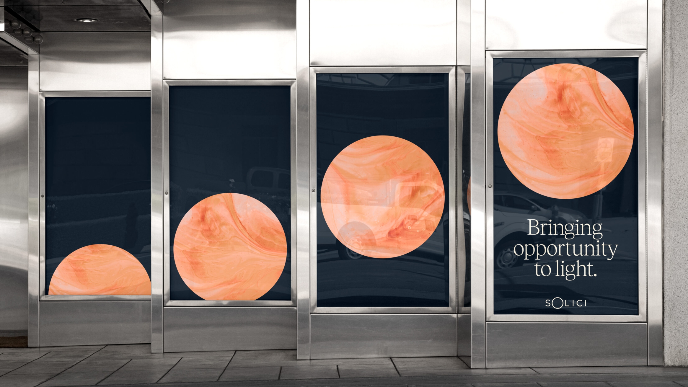 Four posters each with Solici's circle of orange and cream slightly higher as if rising like the sun. Bringing opportunity to light. Solici.
